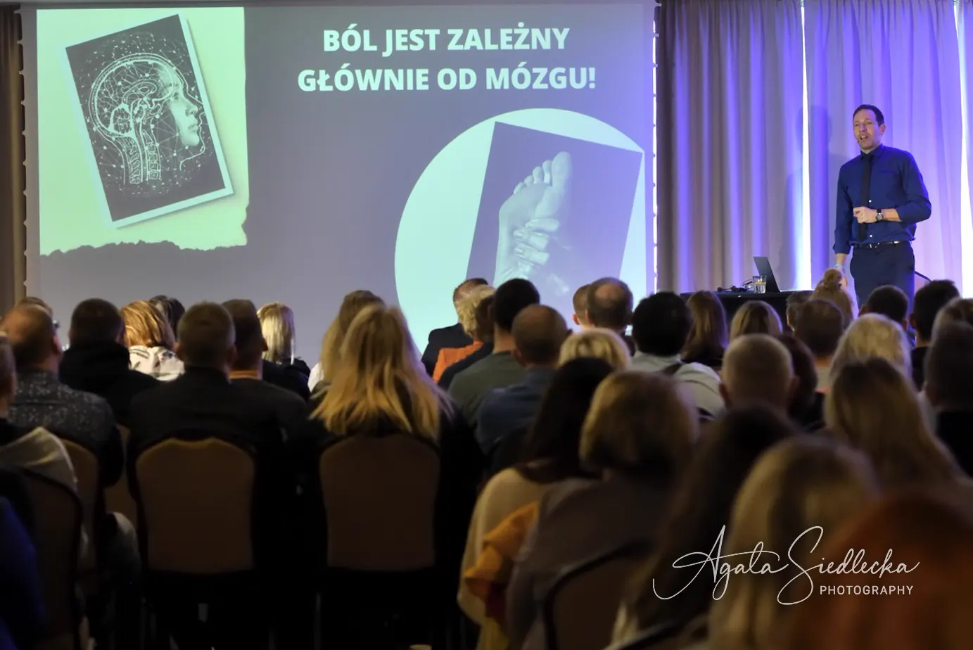 Michał Zarębski prowadzi wykład o bólu przed pełną salą